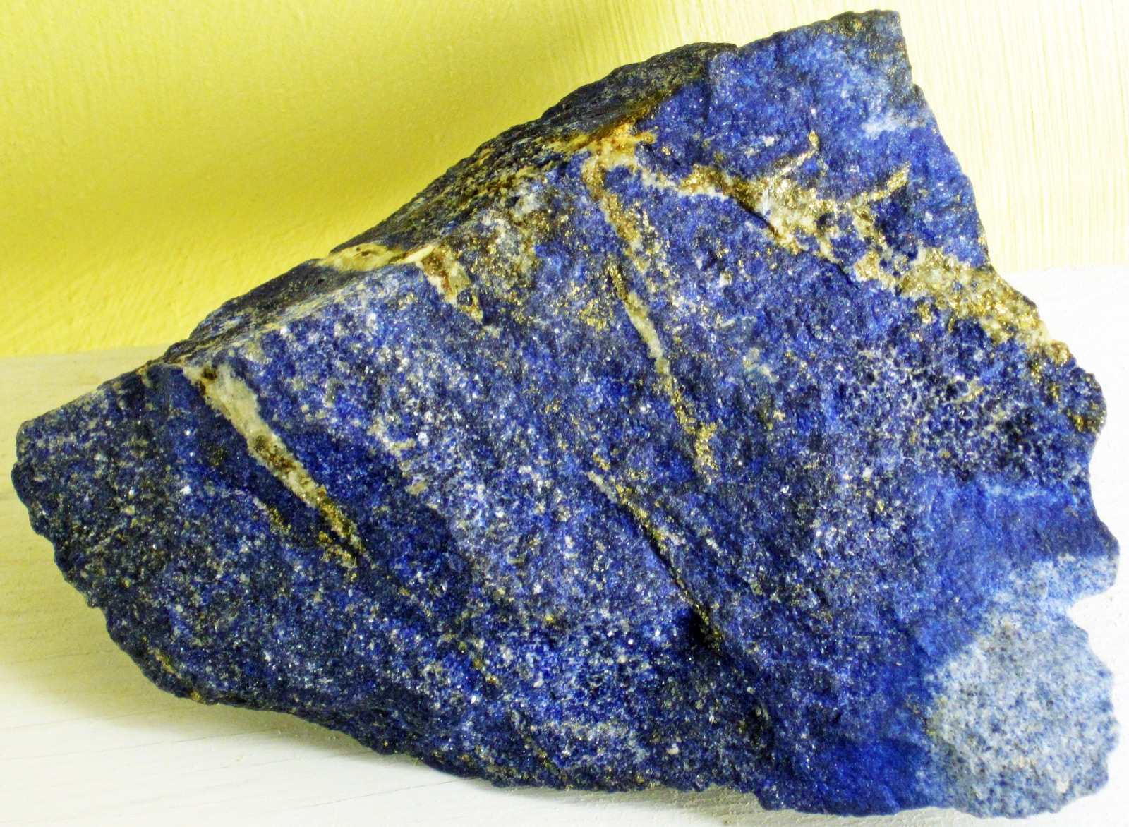 Close-up of Sar-e-Sang lapis lazuli showing deep blue lazurite, white calcite veins and brassy pyrite flecks